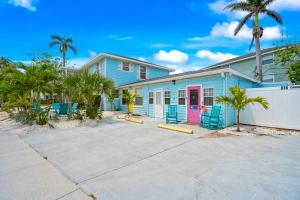 a blue house with a pink door and palm trees at Everglades Villa - Sleeps 8 - Walk to Siesta Beach in Siesta Key