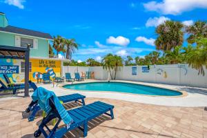 a swimming pool with two blue benches and a playground at Everglades Villa - Sleeps 8 - Walk to Siesta Beach in Siesta Key