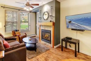 a living room with a fireplace and a tv at Fraser Crossing 3127 in Winter Park