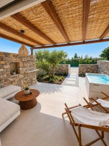 an outdoor patio with a pool and a wooden pergola at Anastasia's Luxury Suite with jacuzzi in Angairiá