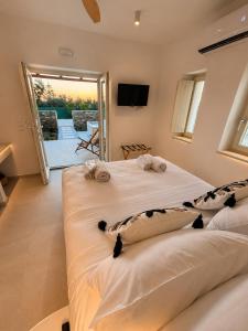 two beds in a room with a balcony at Anastasia's Luxury Suite with jacuzzi in Angairiá +22 photos