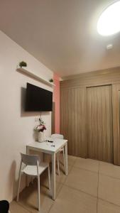 a living room with a table and a tv on a wall at 1556 Shore Residences tower C - MOA in Sampong