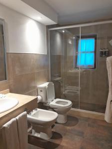 a bathroom with a toilet and a shower and a sink at Hotel Las Cascadas in La Cumbrecita