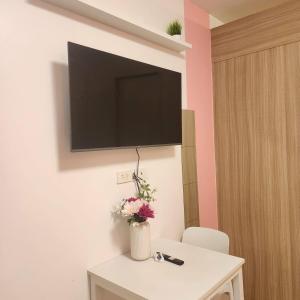 a room with a tv on the wall and a table with flowers at 1556 Shore Residences tower C - MOA in Sampong +42 photos