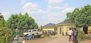 a group of people standing outside of a house at Kolstar Hotel SMC Ltd in Ogwam