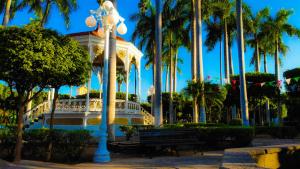 a park with a gazebo and a bench and palm trees at Hotel Santa Elena in El Fuerte