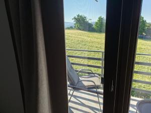 a balcony with a chair and a view of a field at Casa Nițică in Vaslui