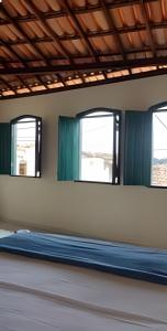 a train room with two windows and a mattress at Casa do Renato Charmosa em Lençóis by LVF in Lençóis