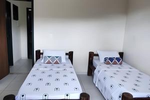 two beds sitting next to each other in a room at Casa do Renato Charmosa em Lençóis by LVF in Lençóis
