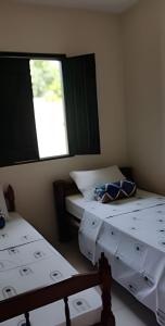two beds in a room with a window at Casa do Renato Charmosa em Lençóis by LVF in Lençóis +28 photos