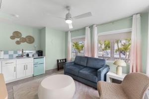 a living room with a blue couch and a kitchen at Hotel Cabana Clearwater Beach in Clearwater Beach