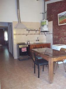 cocina con mesa de madera y fogones en Departamentos Calderon en San Rafael