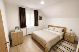 a small bedroom with a bed and a window at Apartmani Resimic in Ivanjica