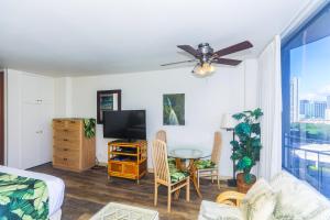 a living room with a television and a table and chairs at Ilikai Marina 1285 in Honolulu