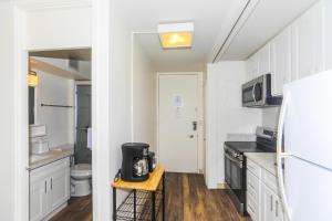 a kitchen with white cabinets and a refrigerator at Ilikai Marina 1285 in Honolulu