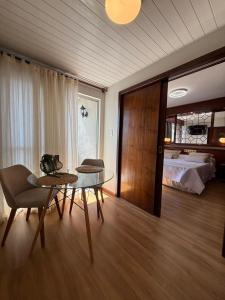 a living room with a table and a bed at Susin Hotel in Mafra