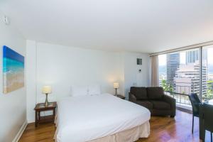 a bedroom with a bed and a chair and a window at Ilikai Marina 1383 in Honolulu