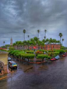 a parking lot with cars and palm trees in a city at Hotel Santa Elena in El Fuerte +30 photos