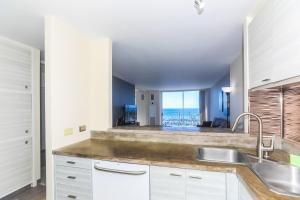 a kitchen with a sink and a view of the ocean at Ilikai Marina 1386 in Honolulu