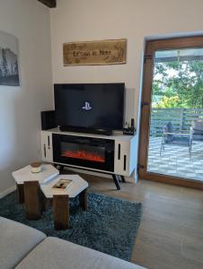 a living room with a fireplace and a tv at La casa de Nora in Duga Resa
