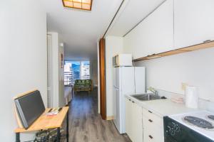 a kitchen with a sink and a table with a tv at Ilikai Marina 1495 in Honolulu