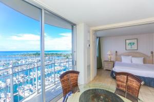 a bedroom with a bed and a view of the ocean at Ilikai Marina 1584 in Honolulu