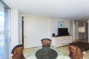 a room with a table and chairs and a television at Ilikai Marina 1584 in Honolulu