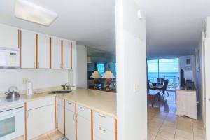 a kitchen with white cabinets and a view of the ocean at Ilikai Marina 1584 in Honolulu
