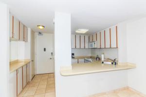 a kitchen with white cabinets and a sink at Ilikai Marina 1584 in Honolulu +23 photos