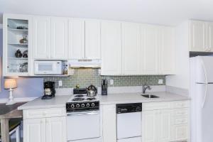 a white kitchen with white cabinets and a sink at Ilikai Marina 987 in Honolulu