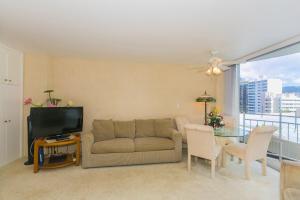 a living room with a couch and a table with a tv at Ilikai Marina 985 in Honolulu