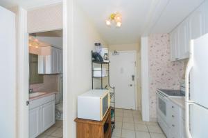 a kitchen with white cabinets and a refrigerator at Ilikai Marina 985 in Honolulu