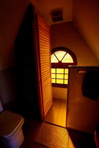 a small bathroom with a toilet and a window at Casa Hotel Antigua Viña in Viña del Mar