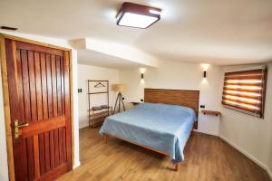 a bedroom with a bed and a wooden door at Casa Hotel Antigua Viña in Viña del Mar