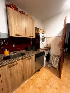 a kitchen with a sink and a washing machine at Santa Maria do Castelo in Sesimbra