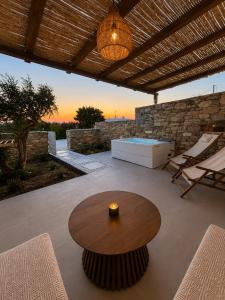 a patio with a table and a bench and a ceiling at Anastasia's Luxury Suite with jacuzzi in Angairiá