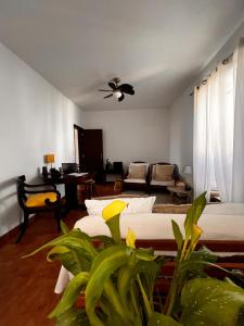 a living room with two beds and a ceiling fan at Santa Maria do Castelo in Sesimbra