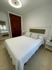 a white bedroom with a large white bed with pillows at Sanpau in Vejer de la Frontera