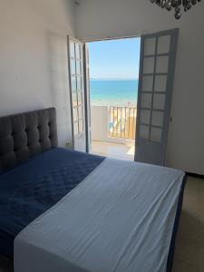 a bedroom with a bed and a view of the beach at Complexe la brise tour 8 appt 815 in La Goulette