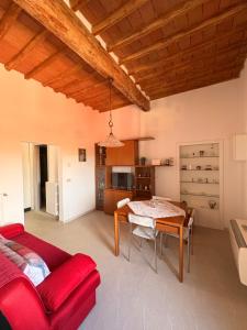 a living room with a red couch and a table at Casa Vicolo in Peccioli