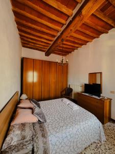 a bedroom with a bed and a desk with a television at Casa Vicolo in Peccioli
