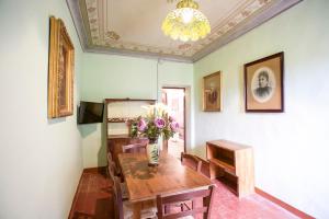 a dining room with a table and a vase of flowers at Appartamento Podere San Marco in Portoferraio
