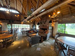 a large room with tables and chairs and a fireplace at Pueblo Chico Agroturismo Hotel in La Floresta