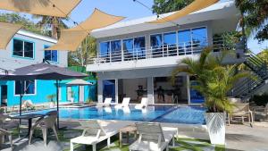 a villa with a swimming pool and a house at Mi Tierra Surf City in El Majahual +22 photos