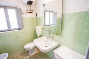 a green bathroom with a toilet and a sink at Appartamento Podere San Marco in Portoferraio +20 photos