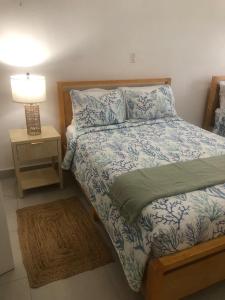 a bedroom with a bed and a night stand with a lamp at Luxury 3BR Villa Belair in Philipsburg