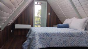 a bedroom with a bed and a staircase with a window at Toca do Caranguejo-Iate Clube Rio Verde - Ilha Comprida in Cananéia +80 photos