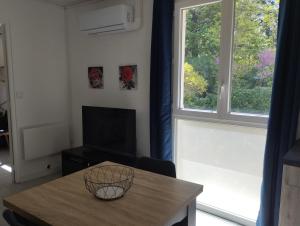 a living room with a table and a large window at L'Uzerois in Uzer