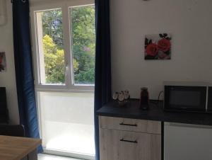 a room with a window and a counter with a television at L'Uzerois in Uzer