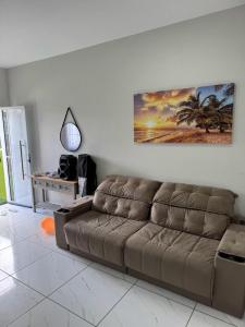 a living room with a couch and a painting on the wall at Toca do Caranguejo-Iate Clube Rio Verde - Ilha Comprida in Cananéia